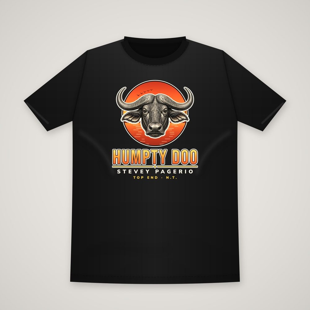 Front of a black t-shirt printed with the Humpty Doo design: an engraved water buffalo head with long curved horns in an orange sunset circle with geese and floodplain water, above the words HUMPTY DOO, STEVEY PAGERIO and TOP END N.T.